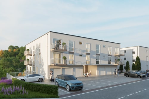 Modernes, weißes Mehrfamilienhaus mit Balkonen und parkenden Autos auf dem Vorplatz an einem sonnigen Tag.